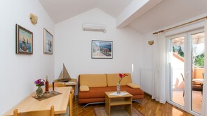 Een moderne woonkamer met een bank, een eettafel en een bijzettafeltje met een vaas.
