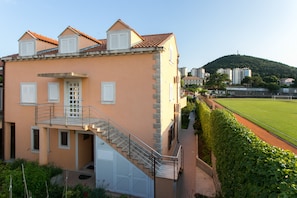 Un bâtiment doté d’un escalier, d’un balcon et offrant une vue sur un terrain de sport.