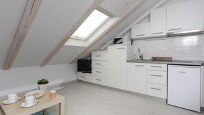 A modern kitchen with white cabinets, a Koncar refrigerator, and a skylight. - Apartments Villa Providenca - Studio (Dubrovnik)