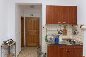 A kitchen with wooden cabinets, a stainless steel sink, and a tiled backsplash.