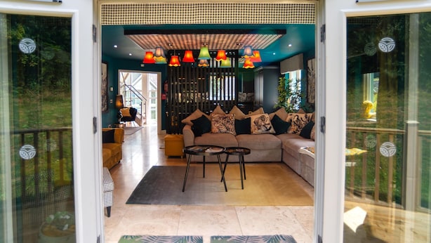 A modern living room with a sofa, two coffee tables, and colorful hanging lamps. - Trewhiddle Villa 03 (St Austell)