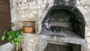 A stone oven with a basket and a plant nearby. - Apartment Marko - Three-Bedroom Apartment with Terrace and Sea View (Brsečine) (Brsecine)
