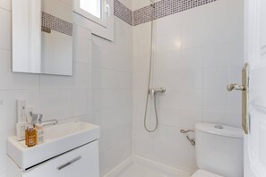 A bathroom with a white sink, mirror, and shower. - Sweett | Rocafort Principal 4 (Barcelona)