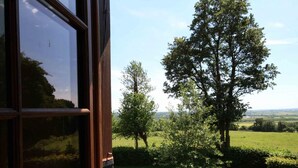 A view from a window overlooking a green landscape with trees and open fields. - Authentic Charm in Bonnevent with View and Calm (Marmouillé)