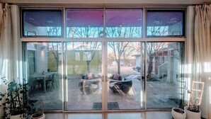 Ein modernes Interieur mit einer großen Glasdoor, die zu einer Terrassenanlage im Freien führt.