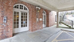 A brick building with arched doorways and a covered walkway. - Riverside Studios (York)