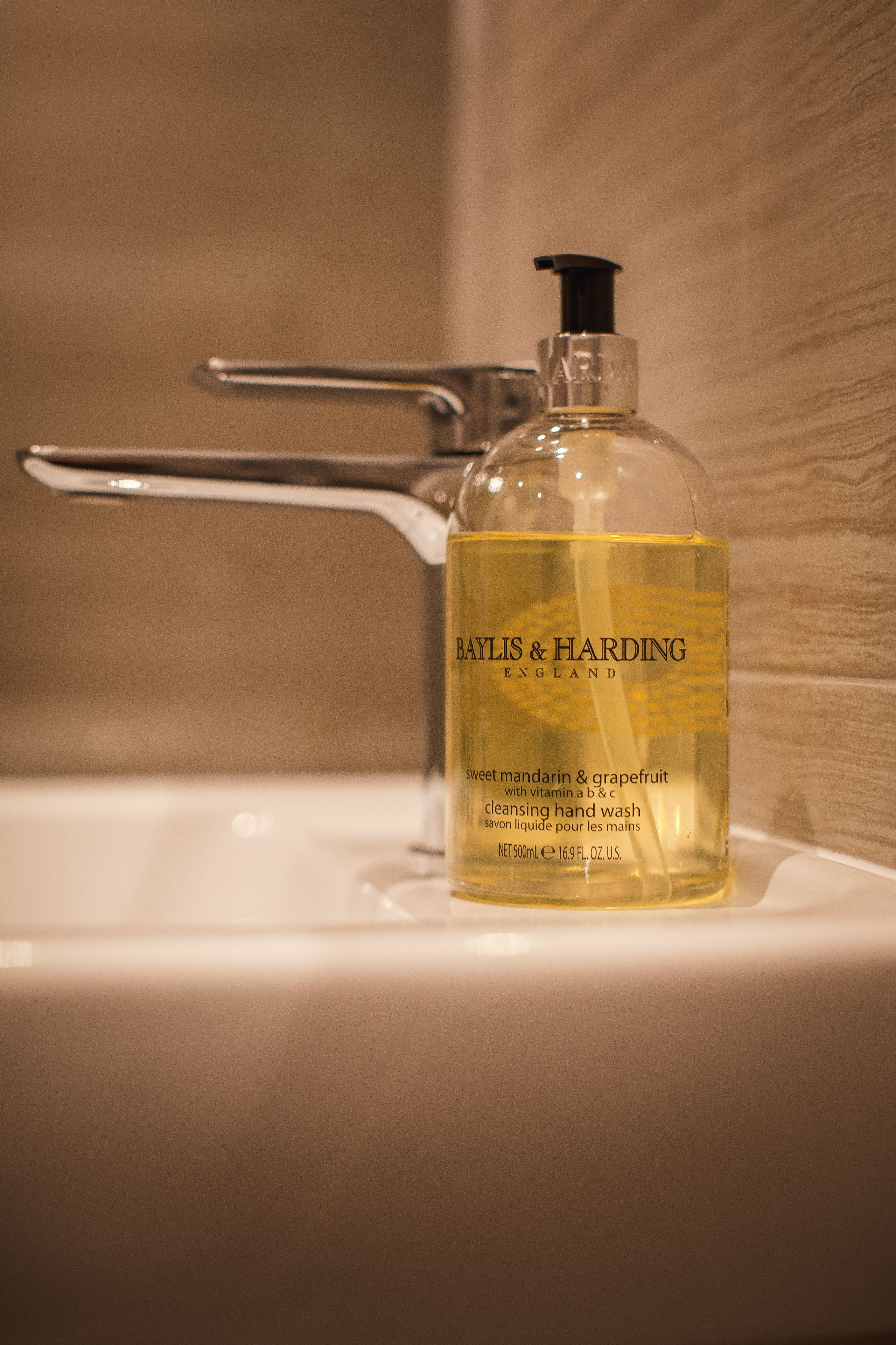 A Baylis & Harding hand wash bottle on a bathroom sink.