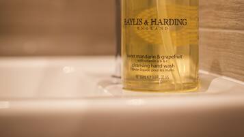 A Baylis & Harding hand wash bottle on a bathroom sink.