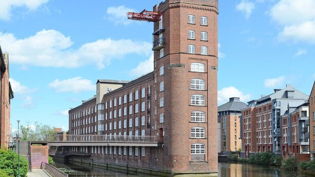 A historic brick building with a tower, a bridge, and a canal. - Riverside Studios (York)