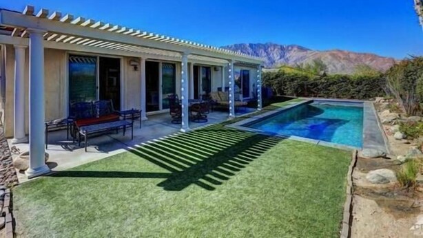 A modern house with a covered patio, a swimming pool, and a mountain backdrop. - Four Seasons Stunner (Palm Springs)
