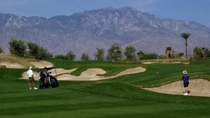 A golf course with a mountainous backdrop, sand bunkers, and a clear sky. - Four Seasons Stunner (Palm Springs)