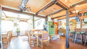 A cozy restaurant with wooden furniture, a green buffet, and a brick floor. - Hotel Lindenkrug (Riepsdorf)