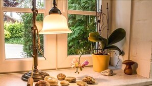 A window ledge with a lamp, a potted plant, and a small orchid. - Hotel Lindenkrug (Riepsdorf)