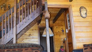 A wooden interior with a staircase, leather sofas, and a wooden door. - Breath Taking Views-Near Yellowstone New Hot Tub.  Just off Union Pass! (Dubois)