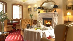 A luxurious room with a fireplace, elegant furniture, and a chandelier. - Bridge House Hotel - Leisure Club & Spa (Tullamore)