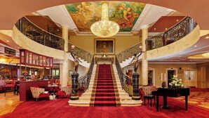A grand lobby with a marble staircase, a chandelier, and a bar area. - Bridge House Hotel - Leisure Club & Spa (Tullamore)