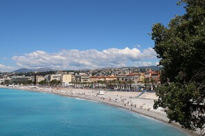 A coastal cityscape with a wide beach, clear blue waters, and a variety of buildings along the shore. - Charming french style in Old Town, renovated, A/C (Nice)