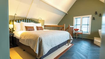 A bedroom with a bed, nightstand, and a window with blinds.