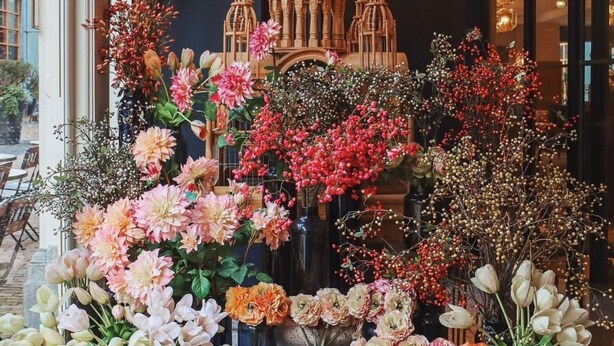 A floral display with various flowers and decorative elements in front of a building facade. - The Collector (The Hague)