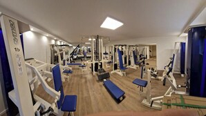 Un gimnasio con diferentes equipos de ejercicio, como bancos y máquinas de pesas.