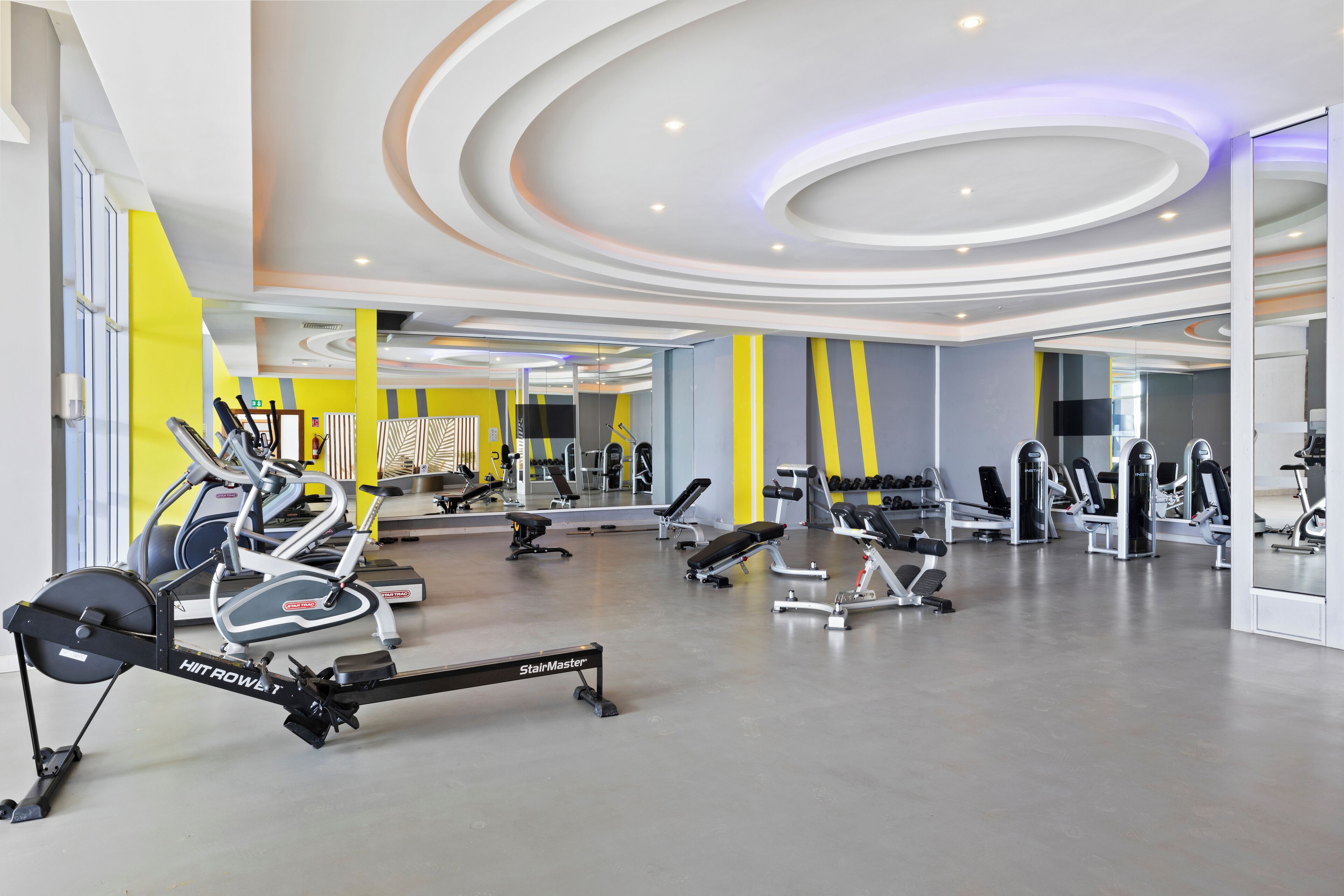 Een moderne sportschool met diverse fitnessapparaten, waaronder loopbanden en krachtapparaten.