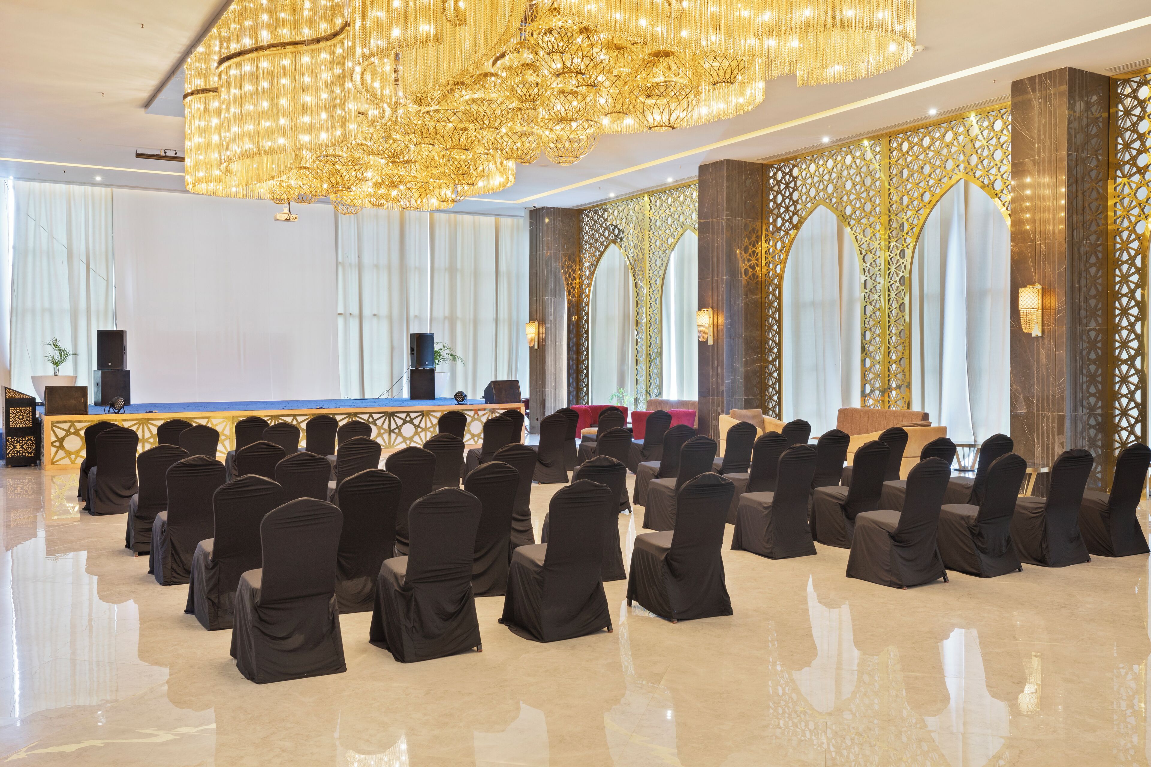 A conference room with rows of chairs, a podium, and a large chandelier.