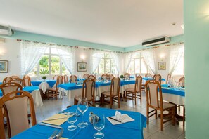 A dining area with tables set for service, chairs, and a window with curtains. - Hotel Park Victoria (Forio)