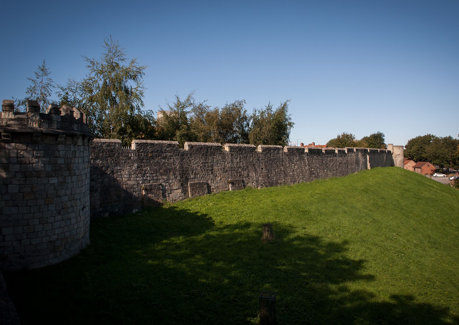 Een stenen muur met een grasrijke dijk, waarschijnlijk onderdeel van een historisch fort.
