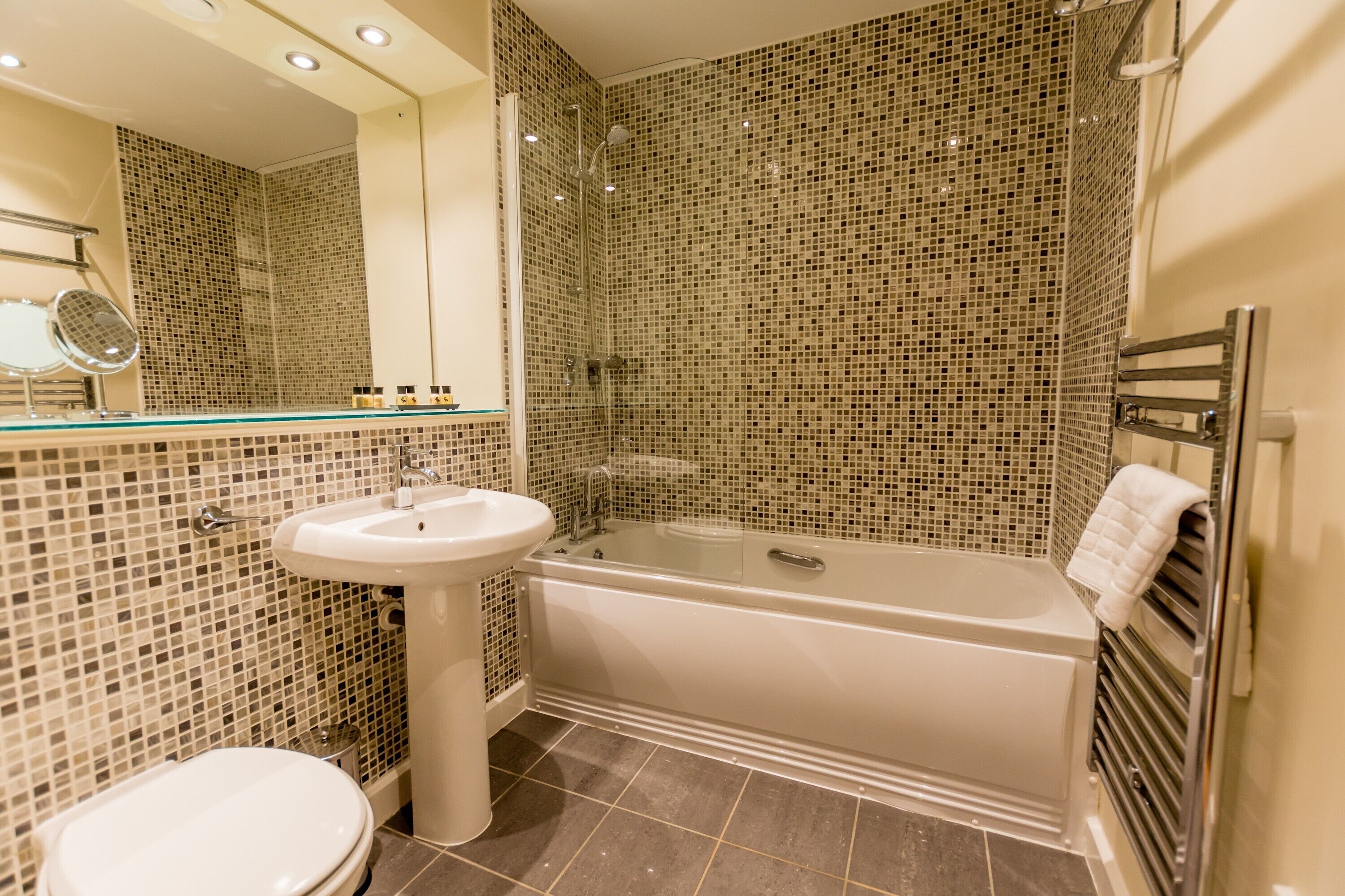 A bathroom with a white bathtub, a sink, and a toilet.