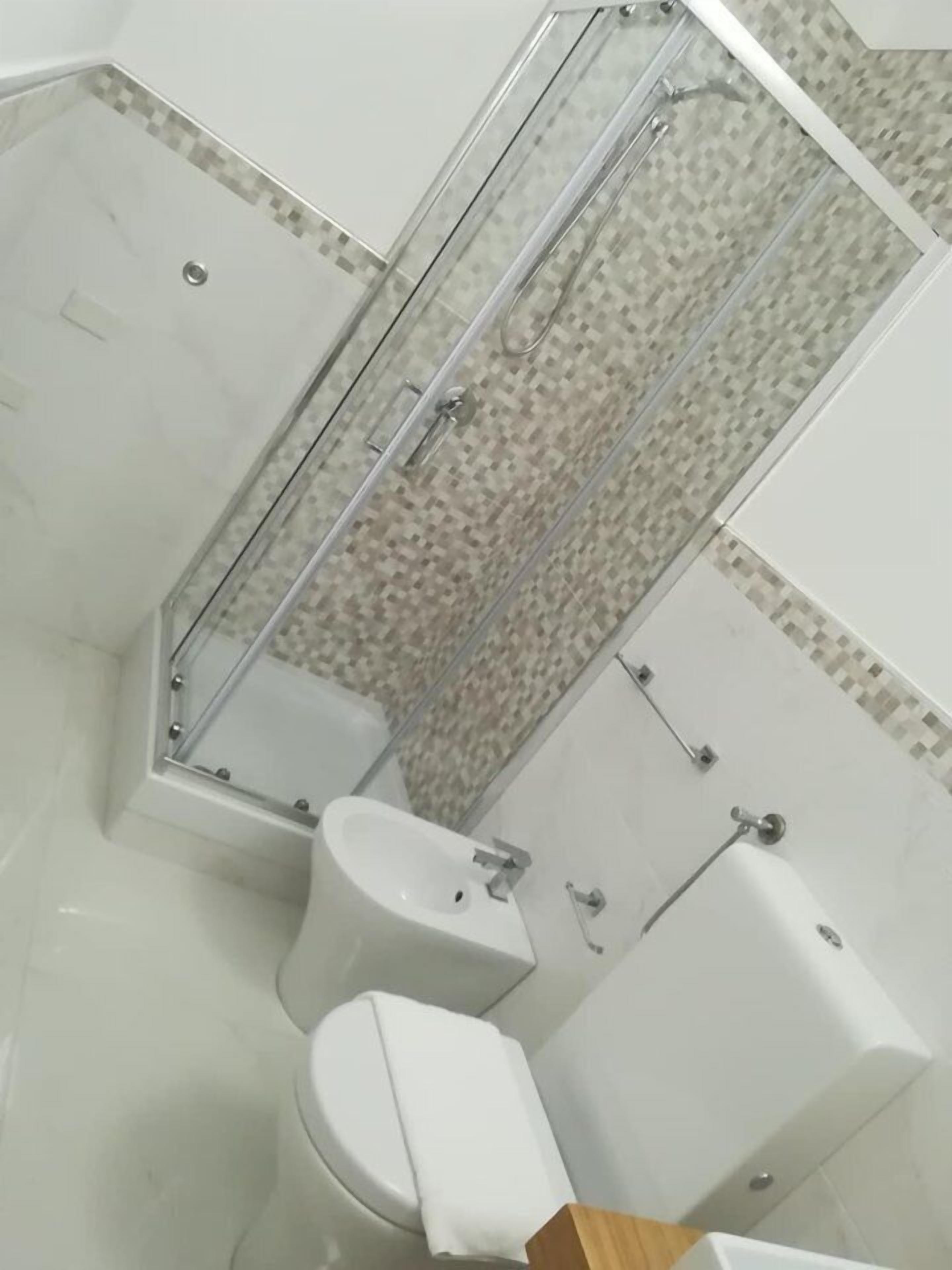 Ein Badezimmer mit Duschkabine, Toilette und Badewanne.