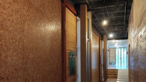 A hallway with a wooden wall and a polished floor, leading to a bright room with a view. - Kaban 44 Hotel (Playa del Carmen)