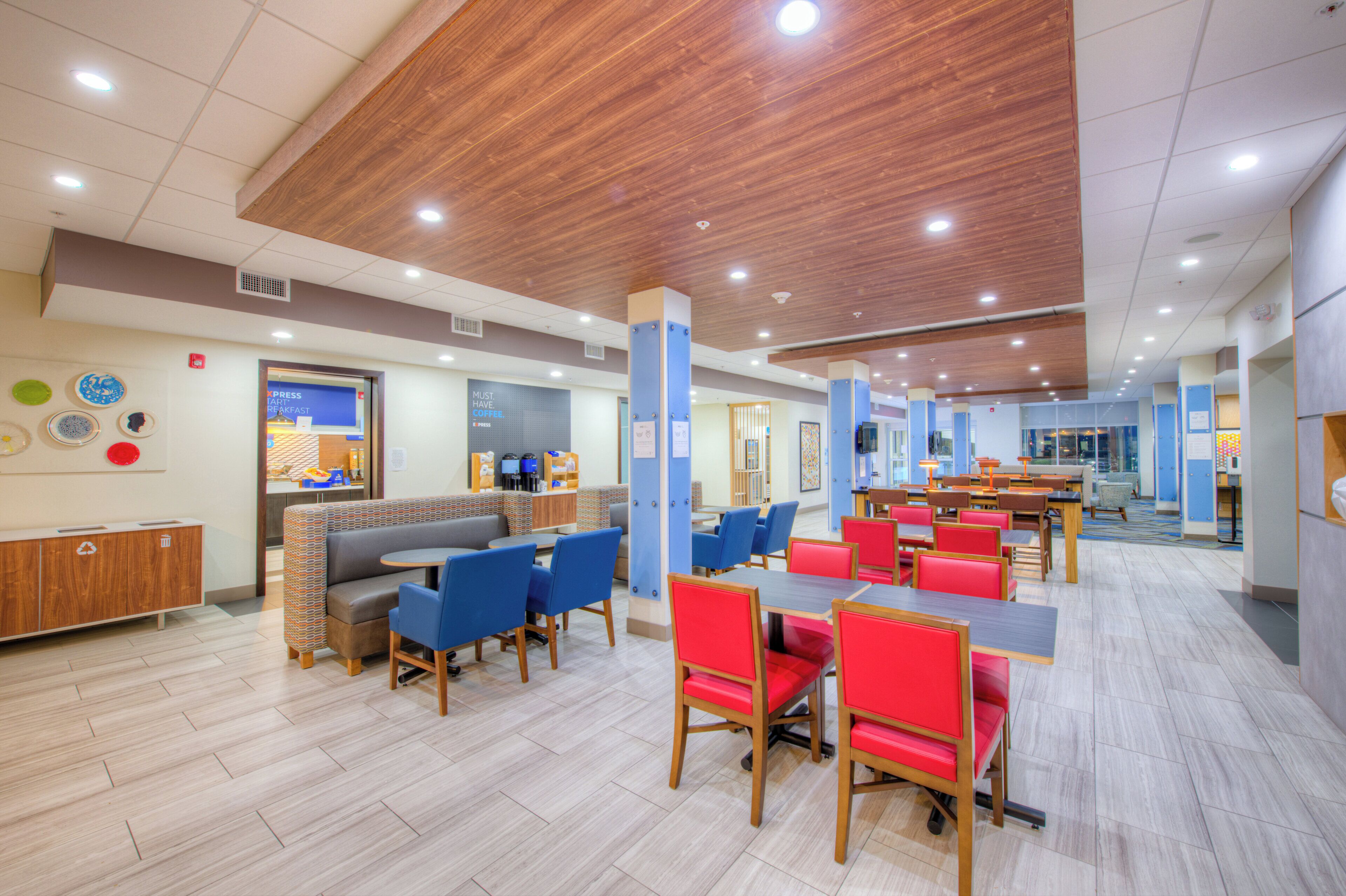 A spacious cafeteria with high ceilings, multiple seating areas, and a variety of tables and chairs.