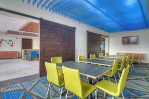 A conference room with tables and chairs, a wooden partition, and a blue ceiling. - Holiday Inn Express & Suites Remington by IHG (Remington)