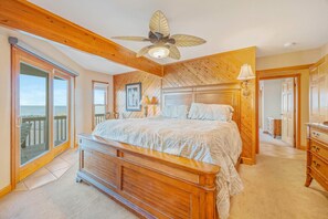 Sleep peacefully in your coastal bedroom where warm wood tones meet ocean breezes, complete with balcony access for morning views. - Premier Oceanfront w/ Private Pool, Hot Tub, Elevator, Sauna, Theater, Game Room (Avon)