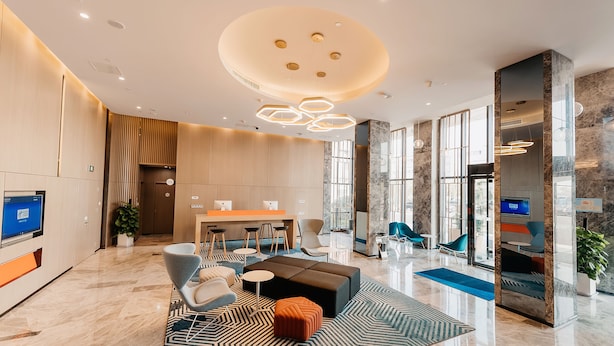 A modern hotel lobby with a reception desk, seating area, and large windows. - Holiday Inn Express Taizhou CMC by IHG (Taizhou)