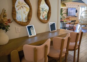 A dining area with a long table, several chairs, and wall-mounted decorative mirrors.