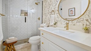 Un baño con ducha, inodoro, lavabo y tocador.