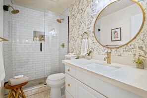 Un bagno con doccia, WC, lavandino e mobile lavabo.