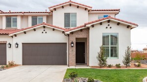 A two-story house with a garage, a brick entrance, and a well-maintained lawn. - Arcadia #37 (Ivins)