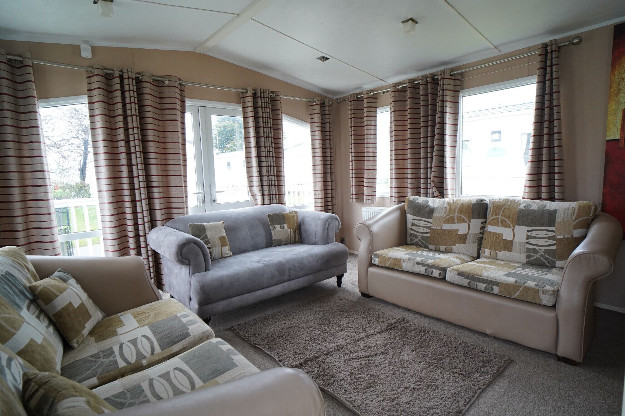 A living room with two sofas, a patterned rug, and curtains.