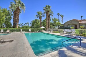 A swimming pool with lounge chairs and palm trees in the background. - Beautiful Gated Country Club, Prime Location (Palm Desert)