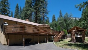 A cabin with a covered porch, a wooden staircase, and a small wooden structure. - Scenic Wonders Apple Tree Home 3 Br (Yosemite National Park)