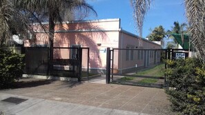 A gated entrance with a metal gate and a building in the background. - Aitue Departamentos (Colon)