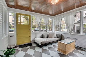 A room with a checkered floor, a wooden ceiling, a yellow door, and a window with curtains. - Minnestay - Grand Residence (St. Paul)