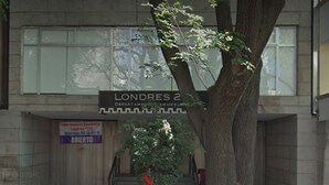 A tree-lined courtyard with a sign for 'Londres 2' and a staircase leading to an upper level. - Suites Londres 212 (Mexico City)