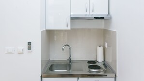 A compact kitchen with a stainless steel sink, a built-in stove, and white cabinets. - Studios IM - Studio Apartment with Shared Terrace (A1) (Dubrovnik)