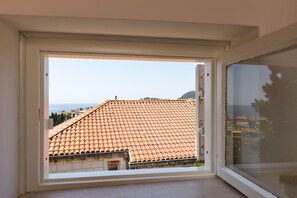 Enjoy a serene view of the distant water and hills from this room's window.