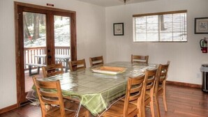 A dining area with a round table covered in a protective sheet, surrounded by wooden chairs. - Scenic Wonders Alder Lodge 3 Bedrooms (Yosemite National Park)