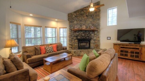 A cozy living room with a stone fireplace, a large TV, and a comfortable seating area. - Scenic Wonders Alder Lodge 3 Bedrooms (Yosemite National Park)