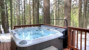 A hot tub on a wooden deck surrounded by a forest. - Scenic Wonders Alder Lodge 3 Bedrooms (Yosemite National Park)